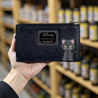 Hocus Pocus Black wallet with cat Binx design held by a hand in front of a blurred store shelf.
