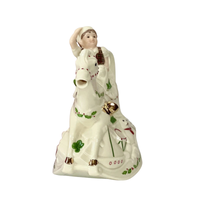 Front view of a Lenox cream colored hand-painted porcelain holiday teapot with a smiling elf with his hand up on a rocking horse with a green paint and 10k gold accents on a white background. 