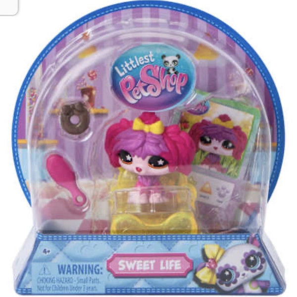 Littlest Pet Shop toy in packaging with pink hair and yellow dress.