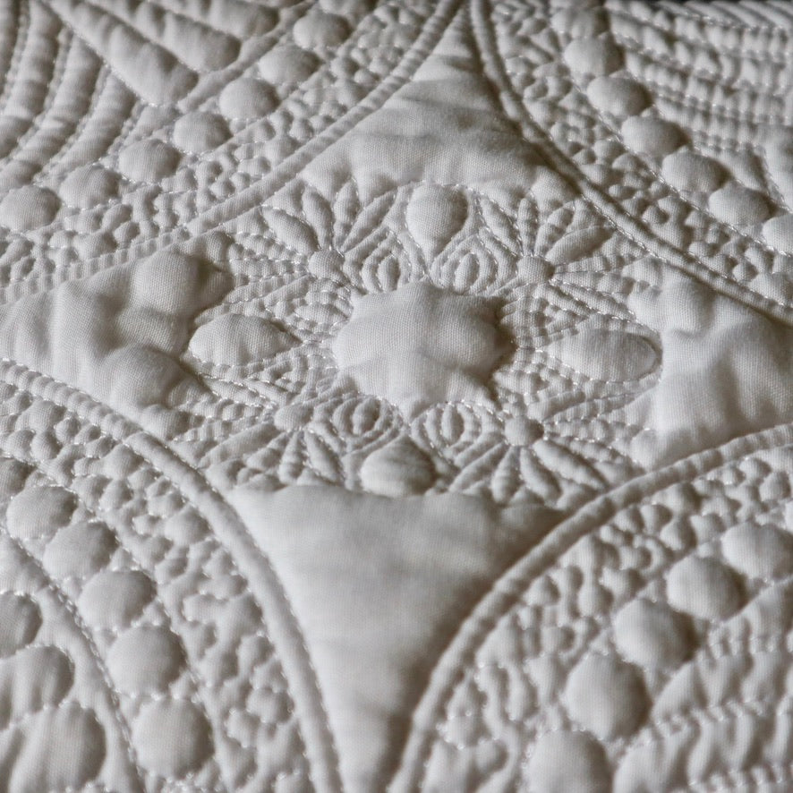 white embroidered baby quilt showing embroidery detail